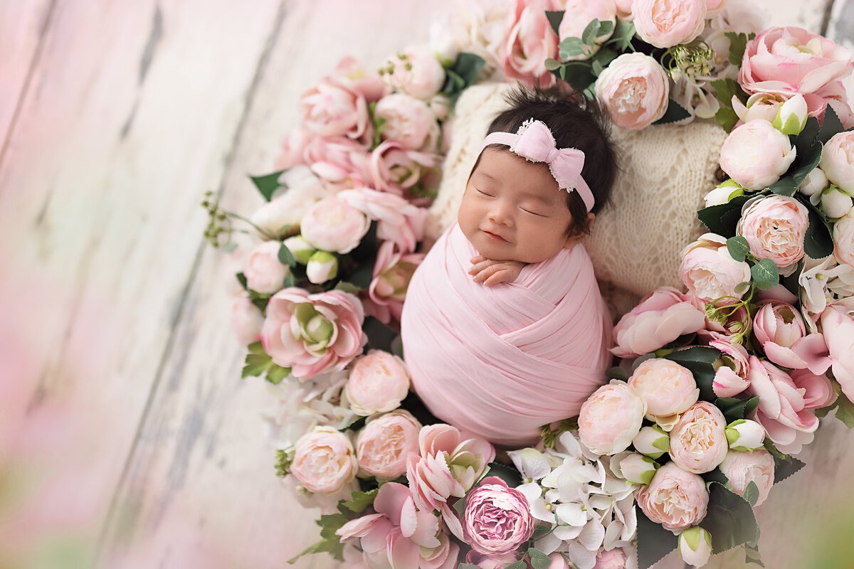 Newborn girl surrounded by pink florals — Toronto newborn photography studio