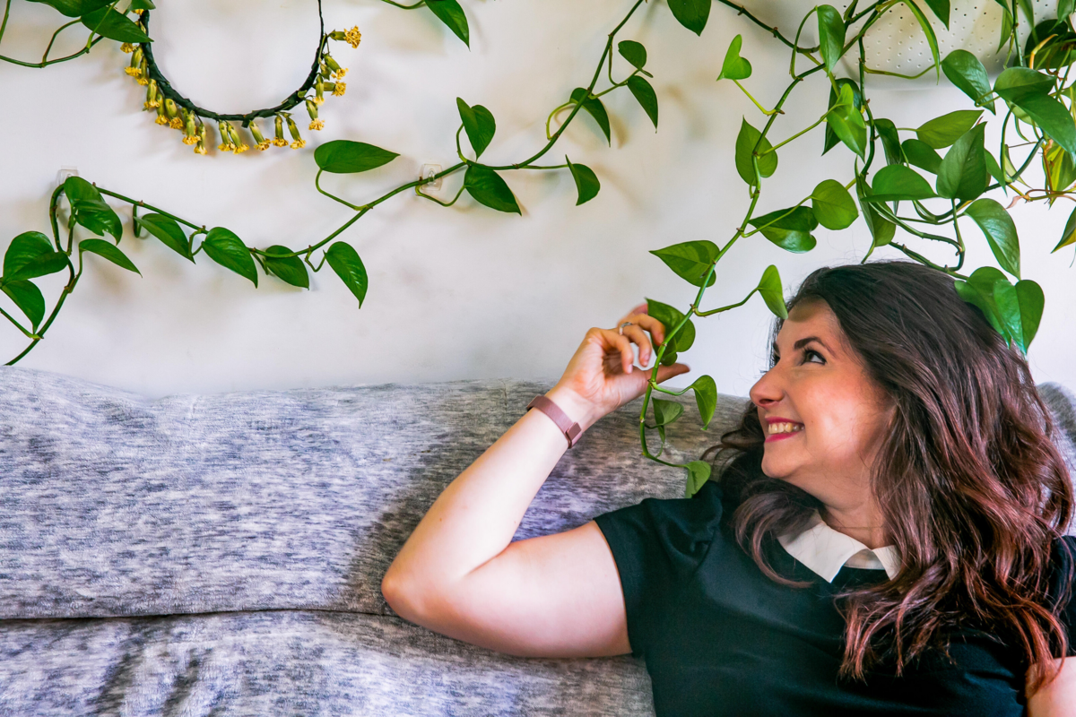 Woman admires her overflowing hanging plants