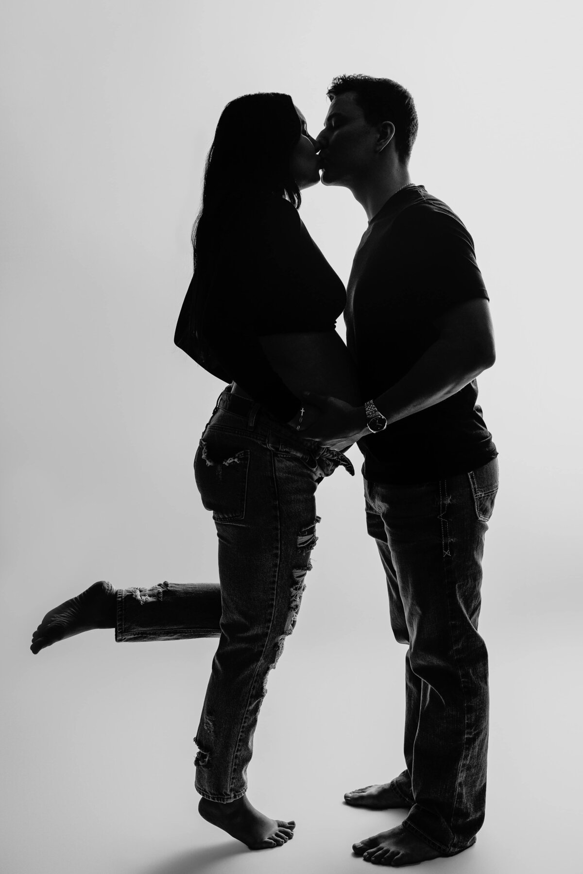 pregnant mom kissing dad in studio