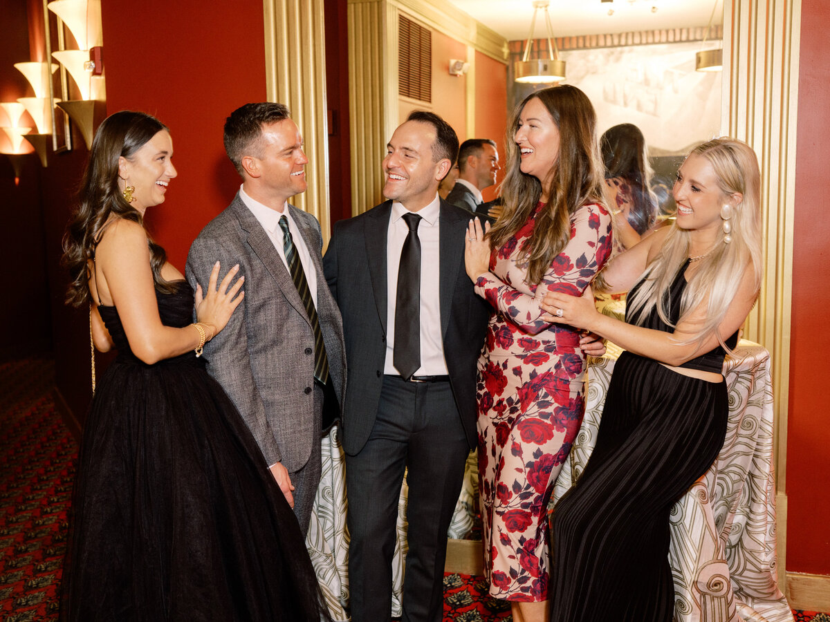 This warm image features a group of friends smiling and interacting at a gathering, radiating joy and camaraderie, showcasing the bonds of friendship in a social setting.