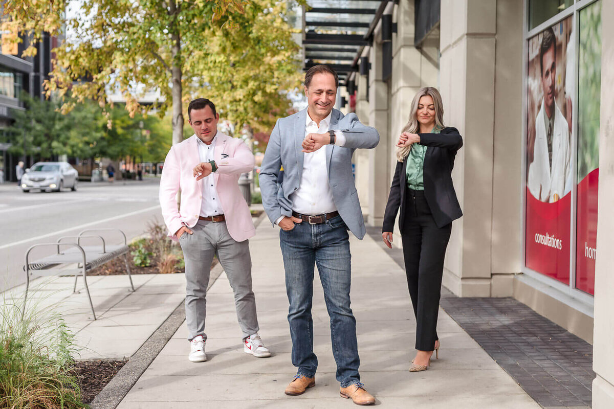 business professionals in urban setting looking at their watches.