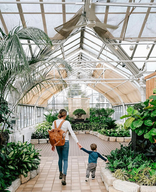 A mother and her son explore the colorful greenhouse at the botanical gardens in Columbus, Ohio, enjoying the greenery.