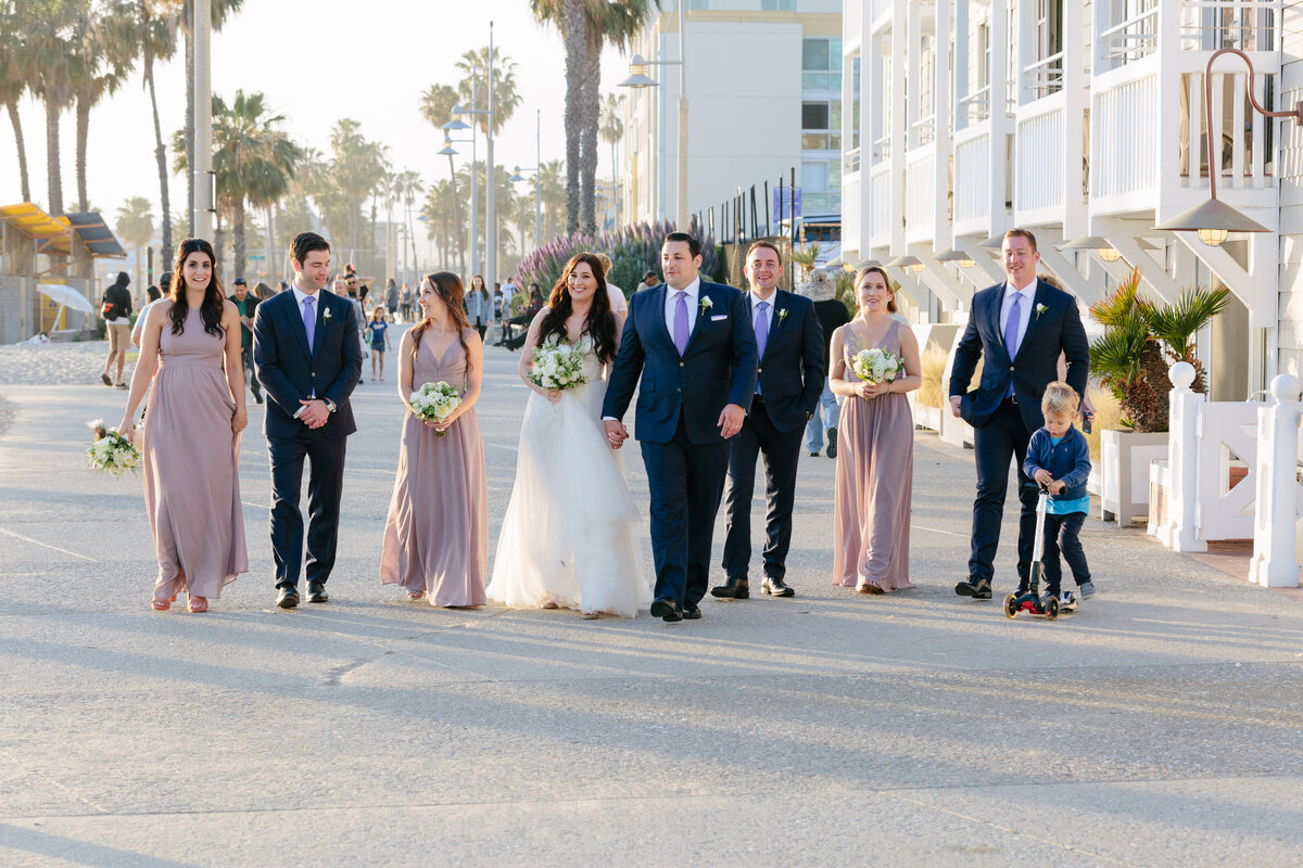 A bride and groom walking together with their bridal parties