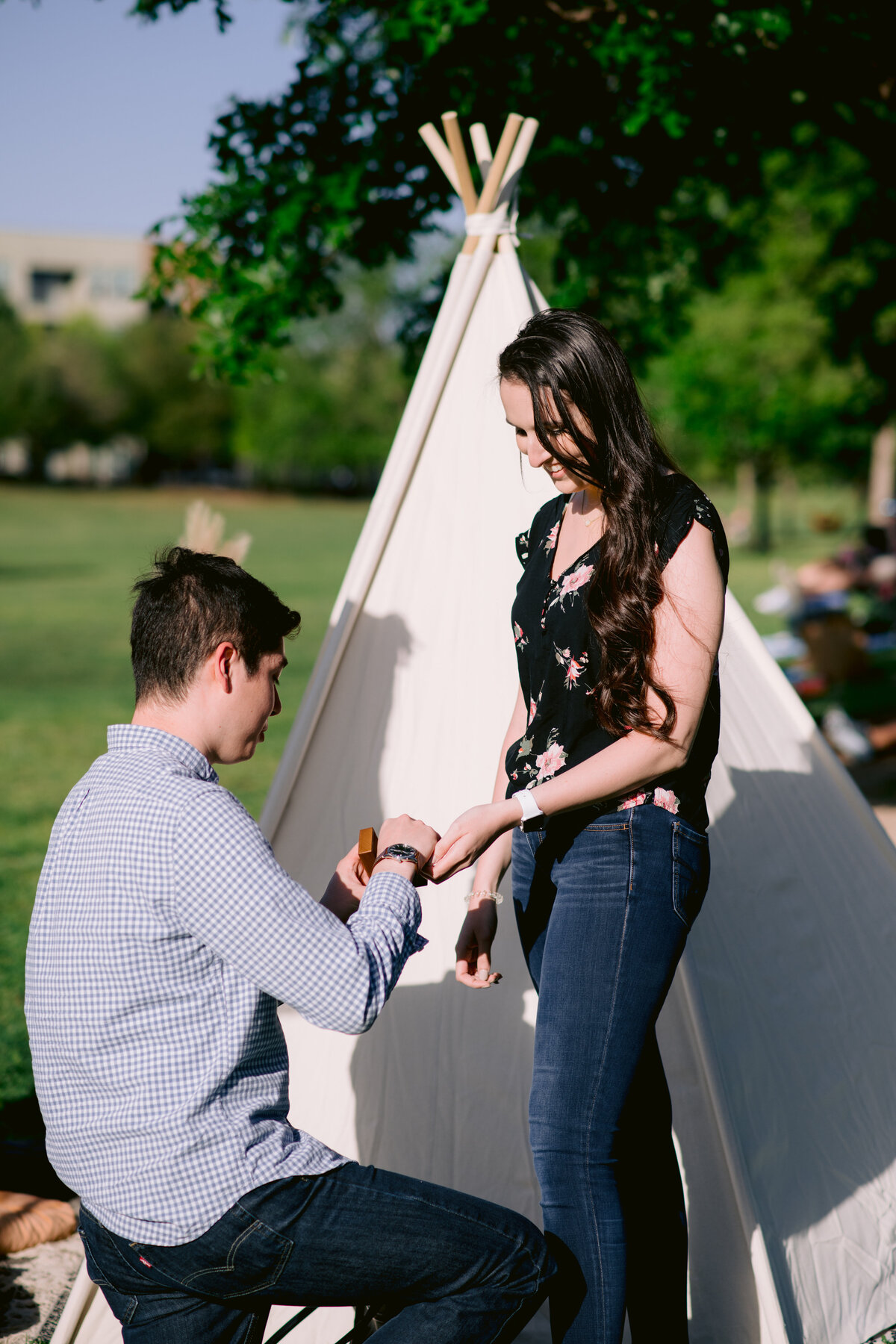 Proposal ideas in Austin man on one knee putting ring on woman's finger