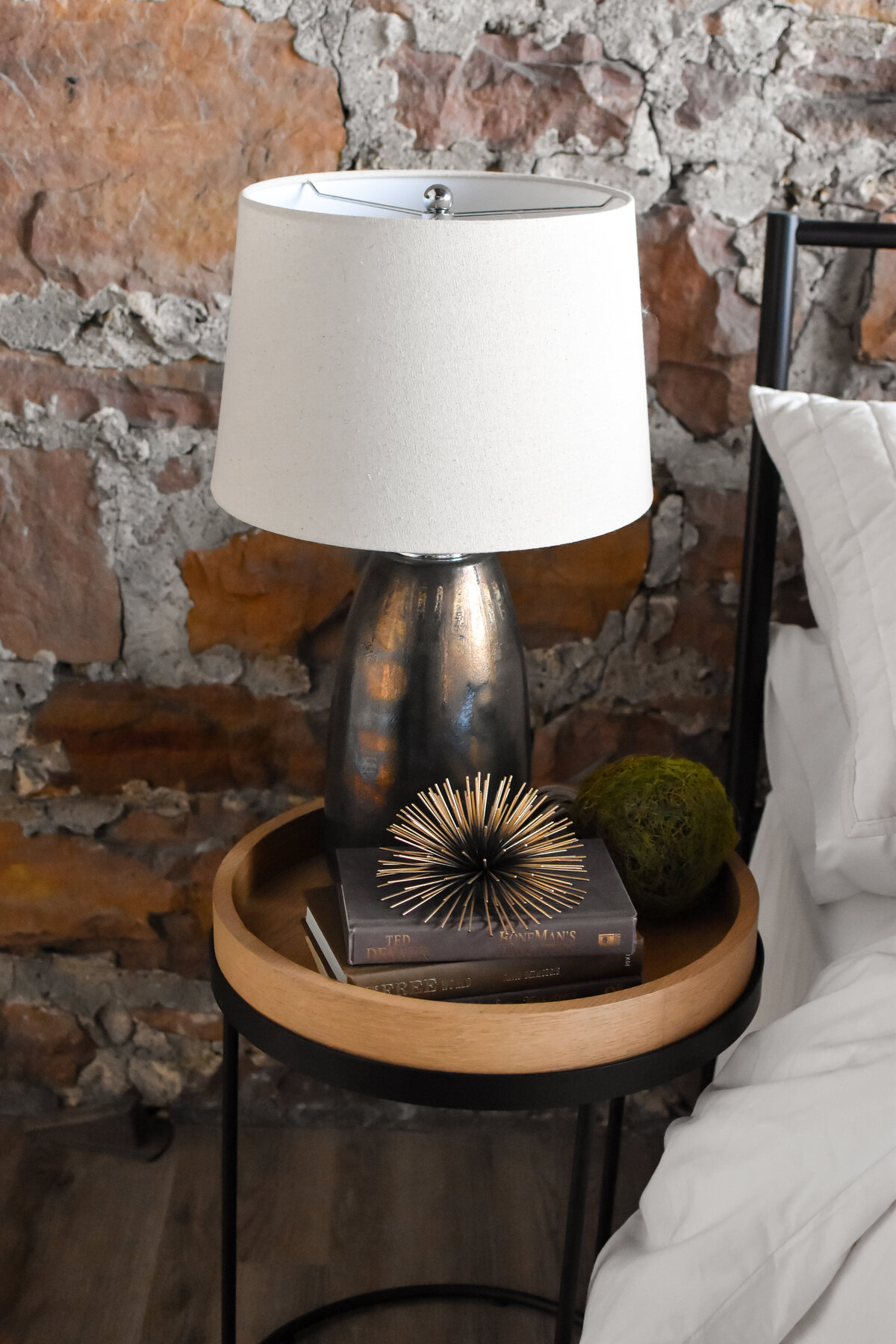 A small lamp sits on a style bedroom end table