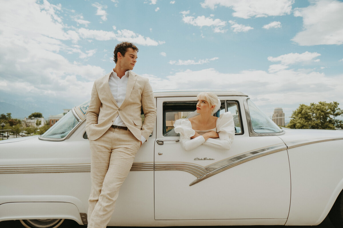 bride and groom looking at each other in a vintage car