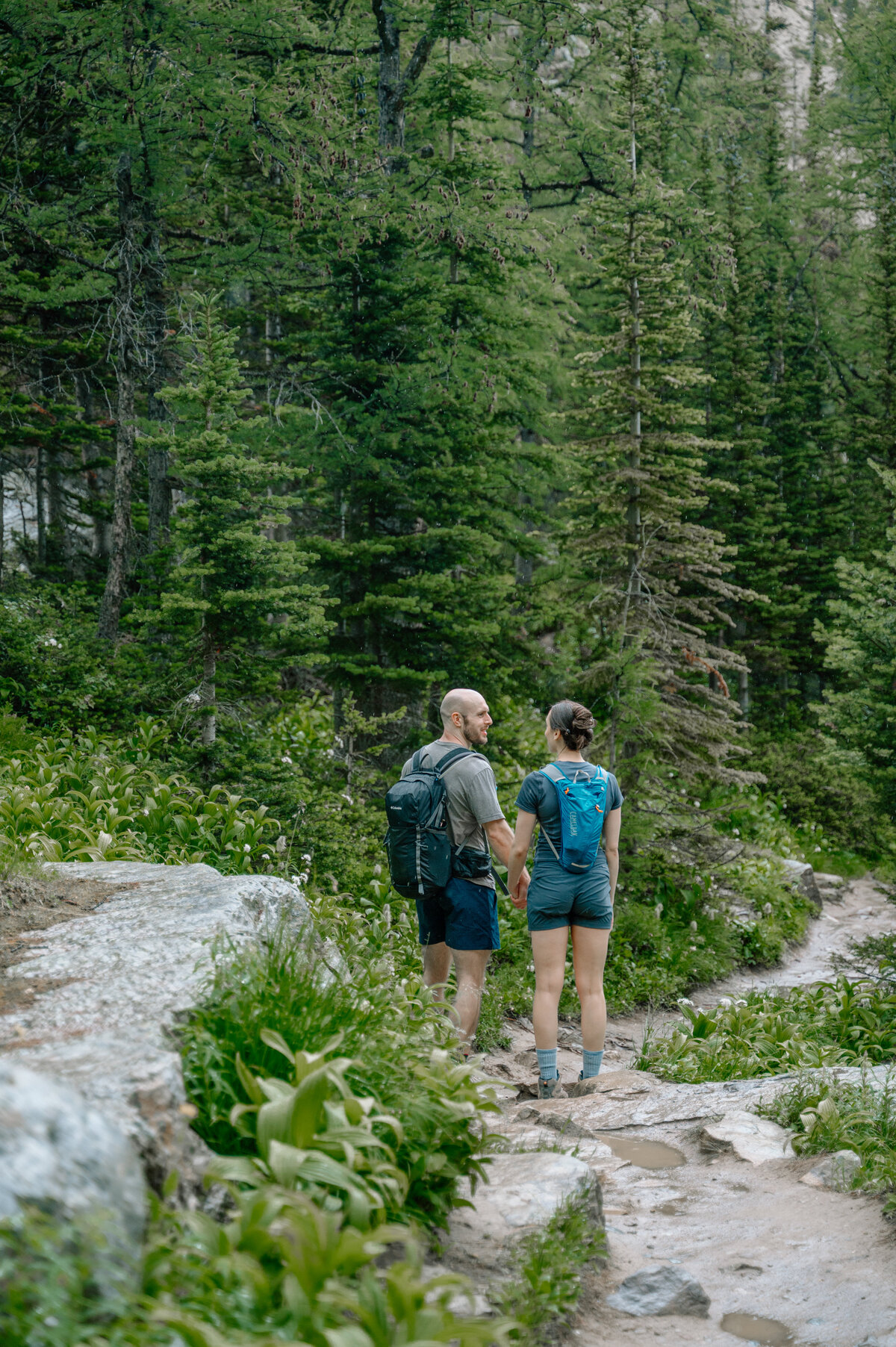 Adventurous hike together on trail at lake louise, captured during a stunning mountain engagement session.