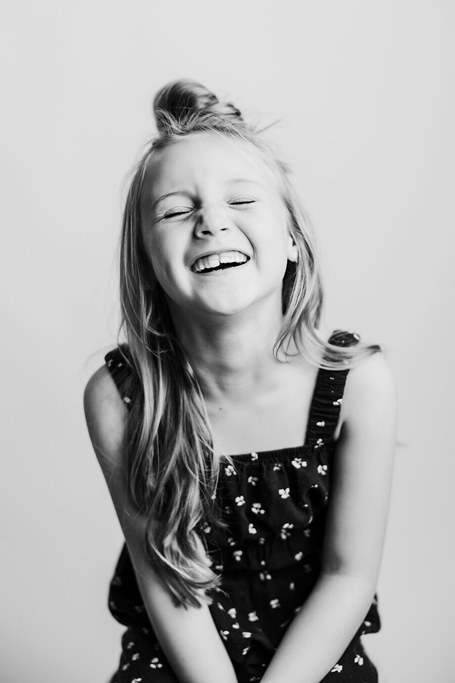 Little girl laughing at the camera in her studio black and white portrait session