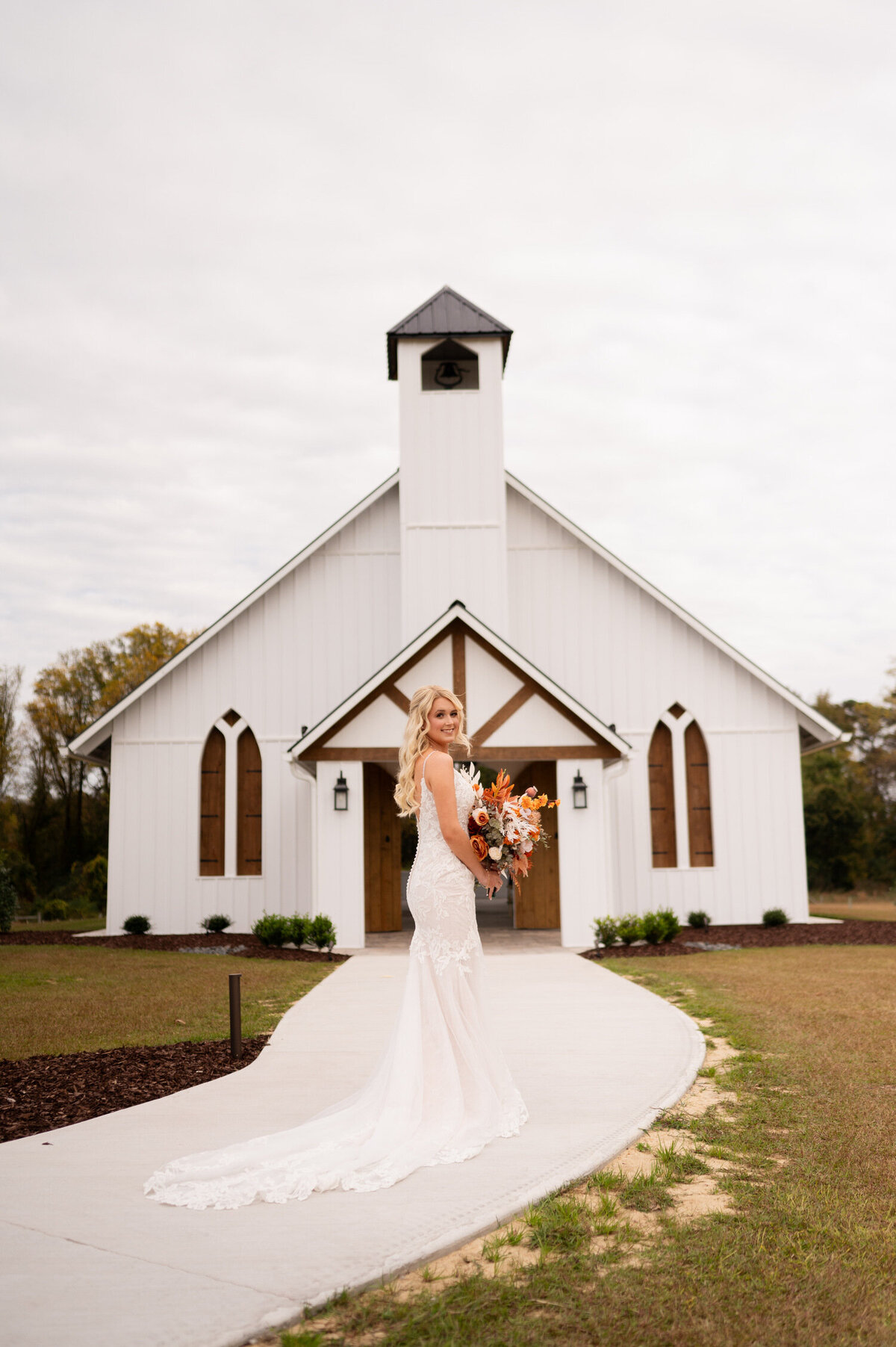 A portrait of the bride in front of the chapel during her wedding ay Stokes Family Farm in Greenville, NC.