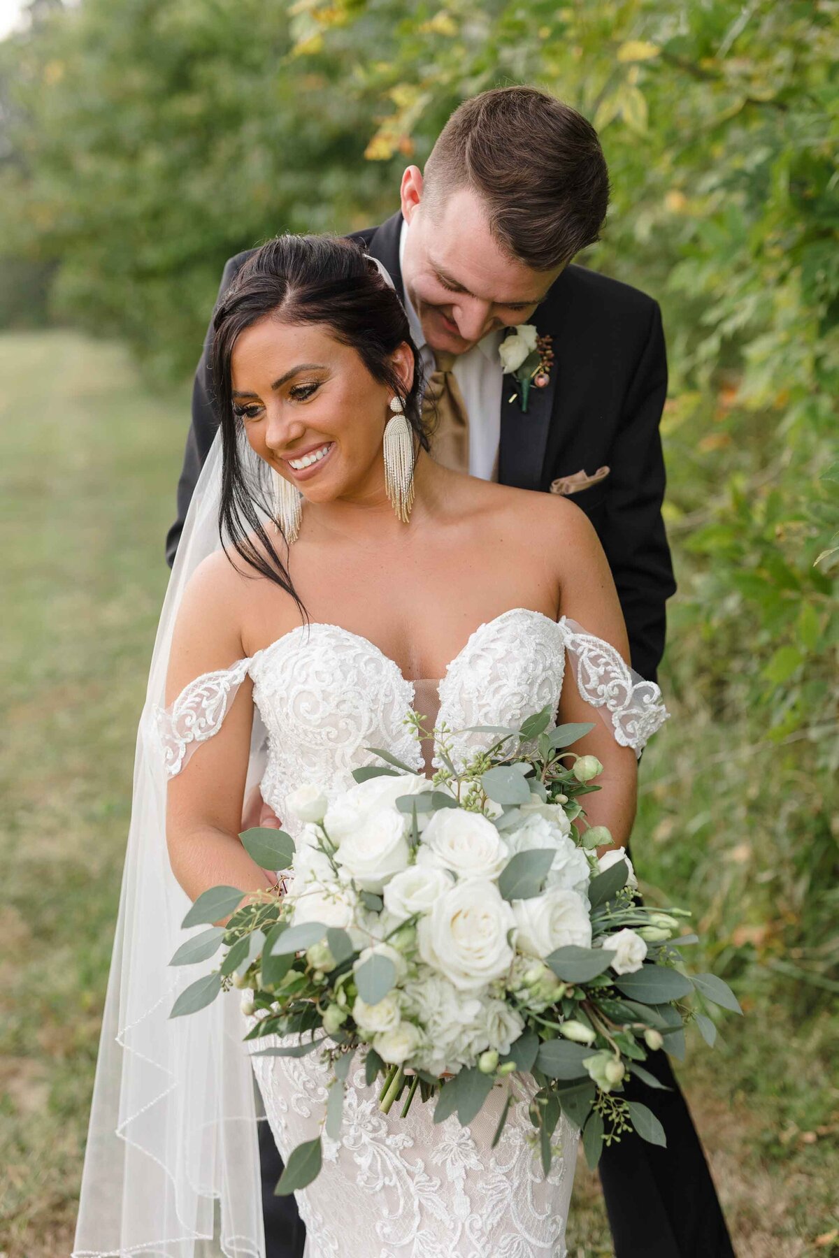 Bride and groom posing with beautiful bouquet