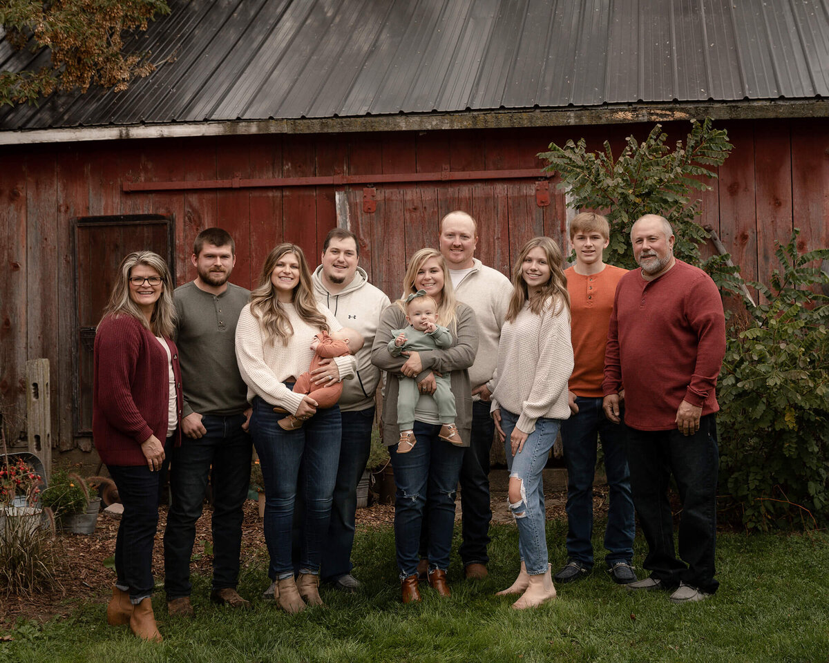 Extended family of 9 standing in front of a barn.