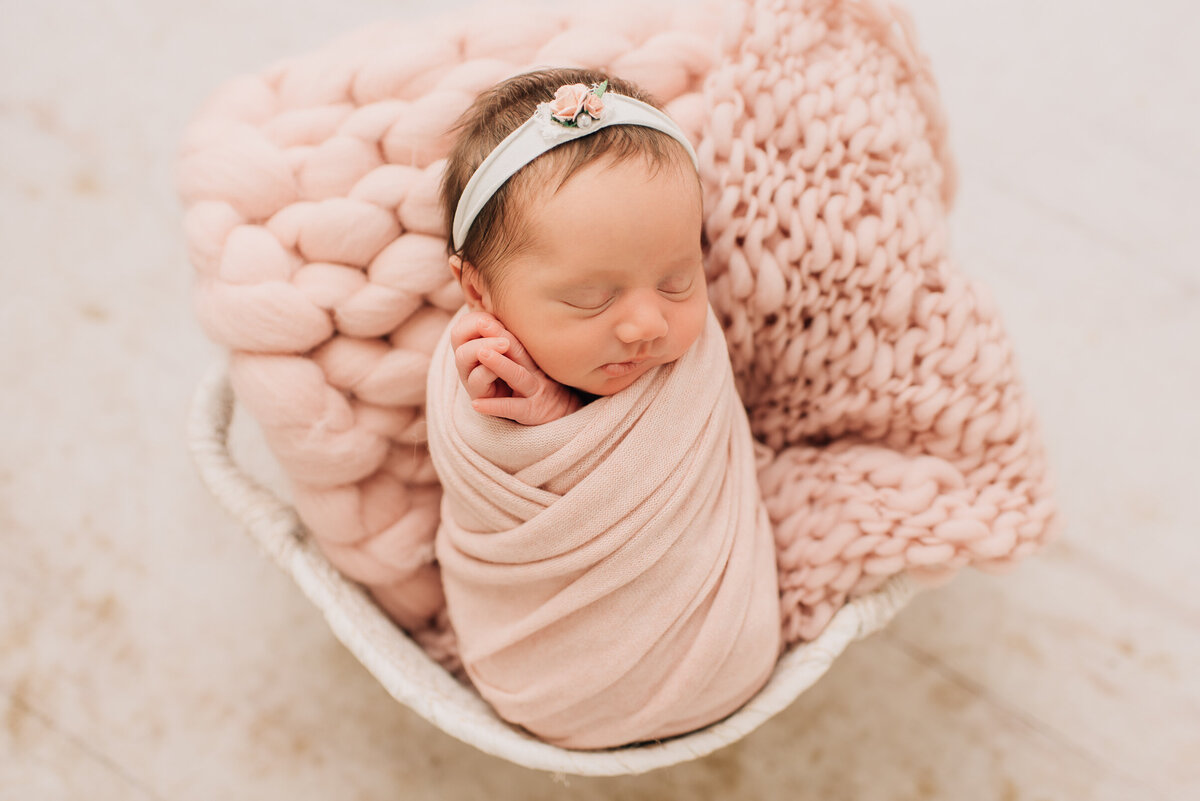 A baby girl wrapped in pink at her newborn session with Sharon Leger Photography.