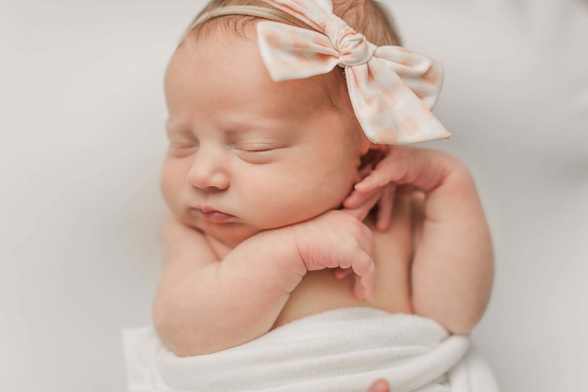 posed baby on light backdrop during an in-home newborn session in Cincinnati