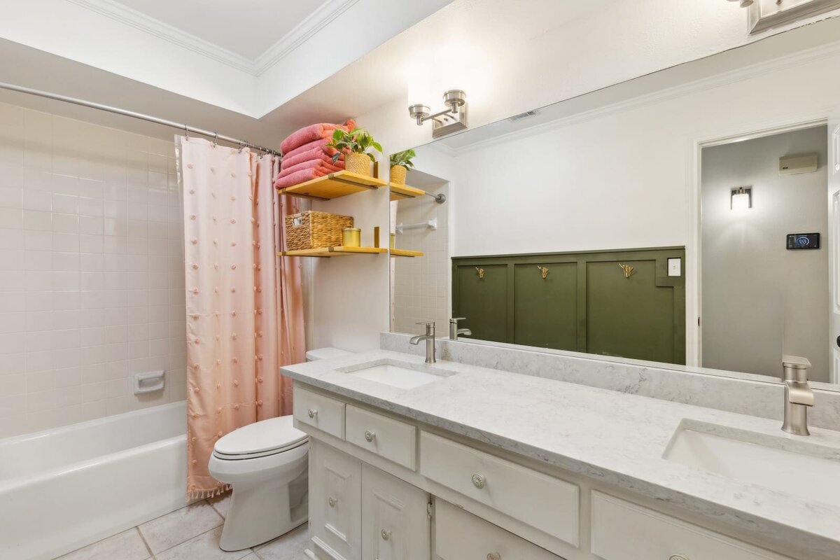 10216_shadow_way_dallas_tx_guest_bathroom_with_double_sink_vanity_shelving_and_tub_combo_haven_realty_group