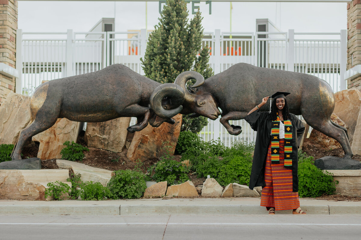 In front of Canvas Stadium at Colorado State University in Fort Collins, a graduate poses for a portrait to commemorate their academic achievement.