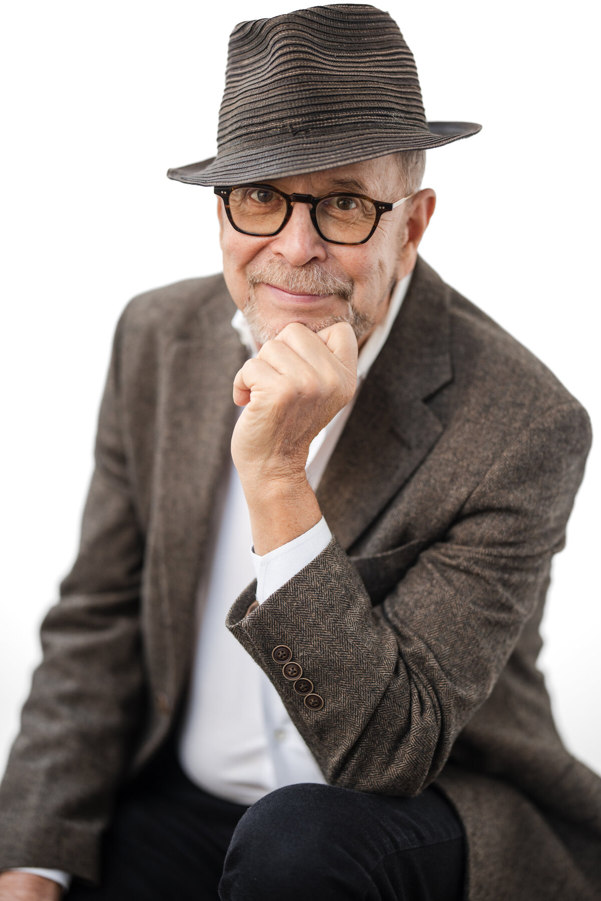 A dapper man in a hat poses for his NYC author photo session.