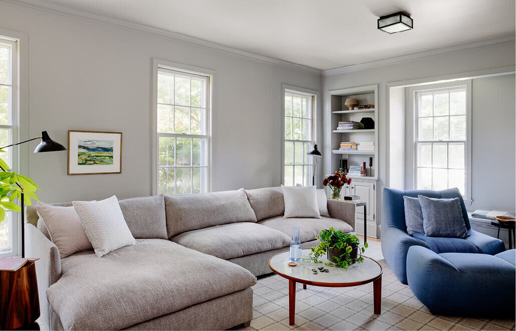 Light grey family room with modern furniture, designed by South Shore interior design firms, creating a sleek and timeless space with clean lines and contemporary style.
