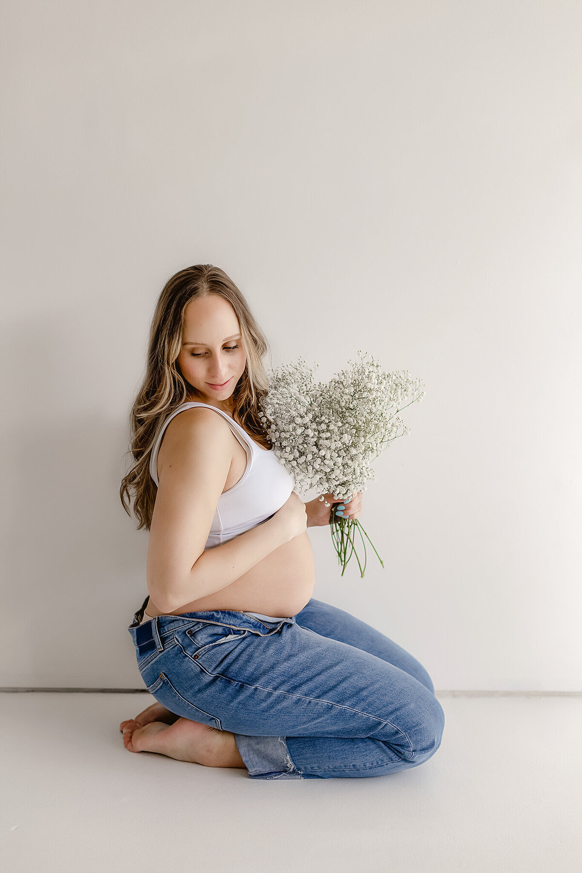 om holding a bouquet of flowers  for a fun studio maternity photography session in denver colorado