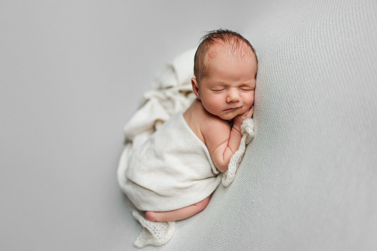 baby on white backdrop for newborn photos