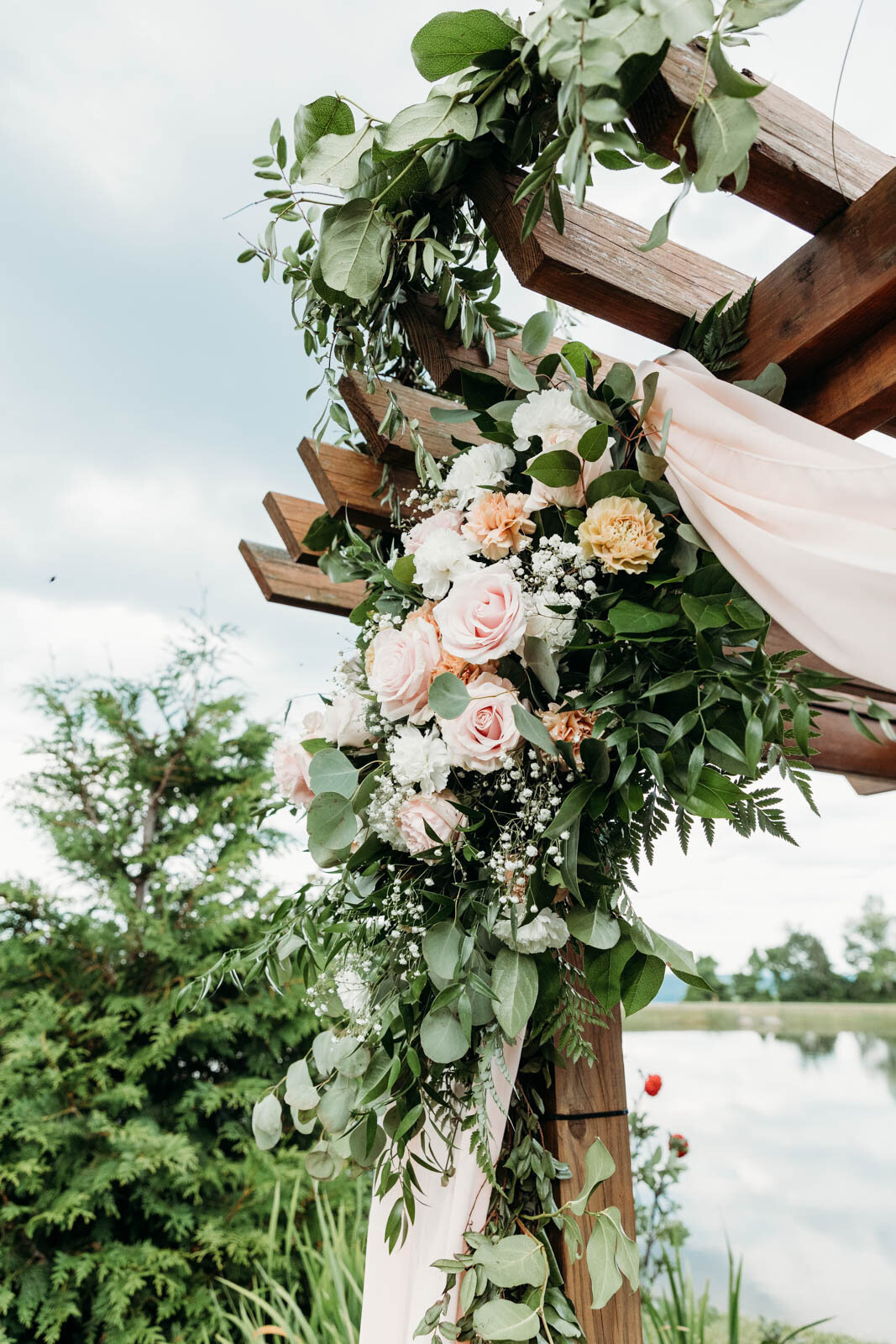 Details of pink florals decorating a wooden pergola