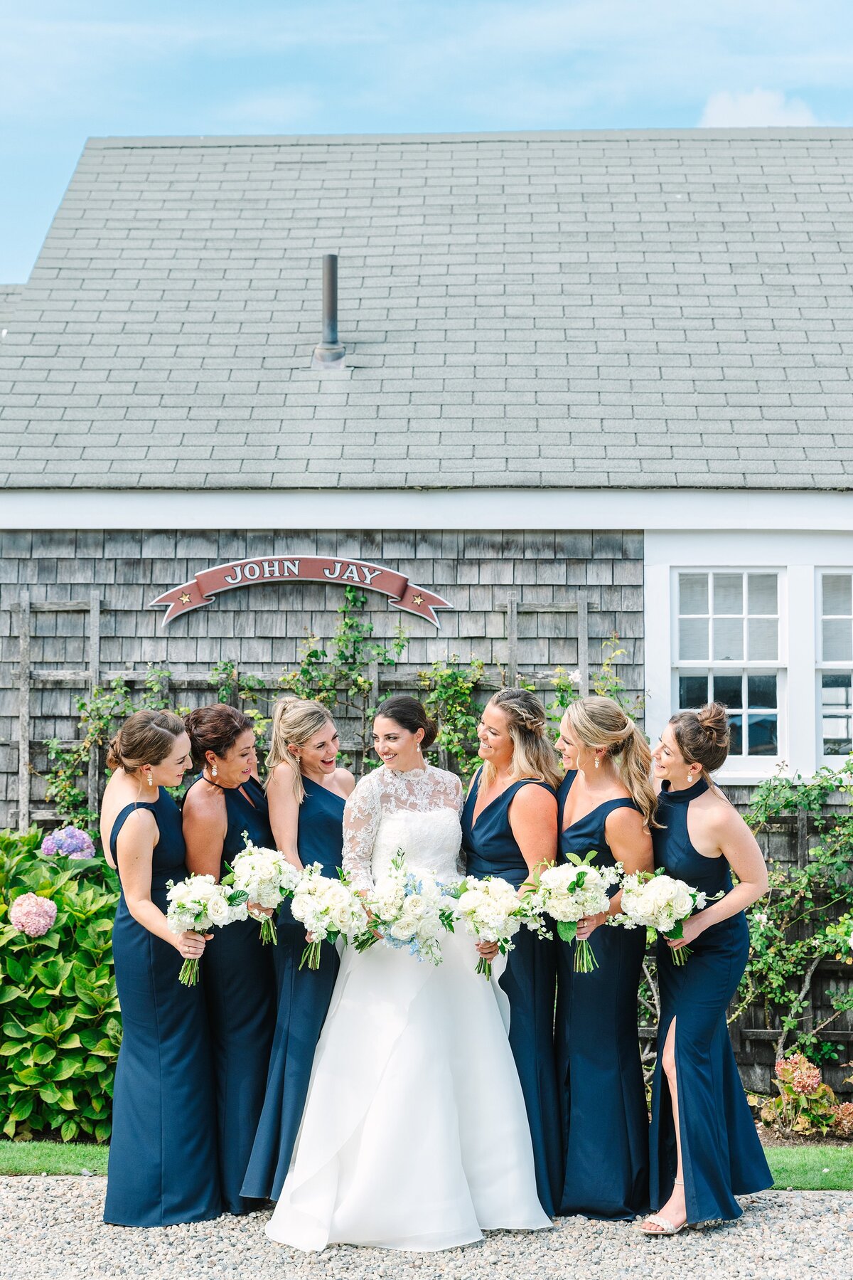 bride with bridesmaids in navy dresses with white bouquets