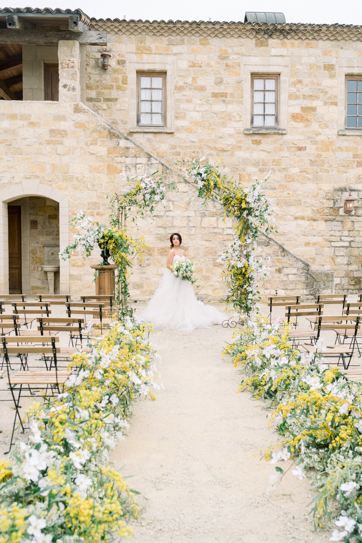 Bride at ceremony flower arch at Sunstone Winery in Santa Ynez, CA