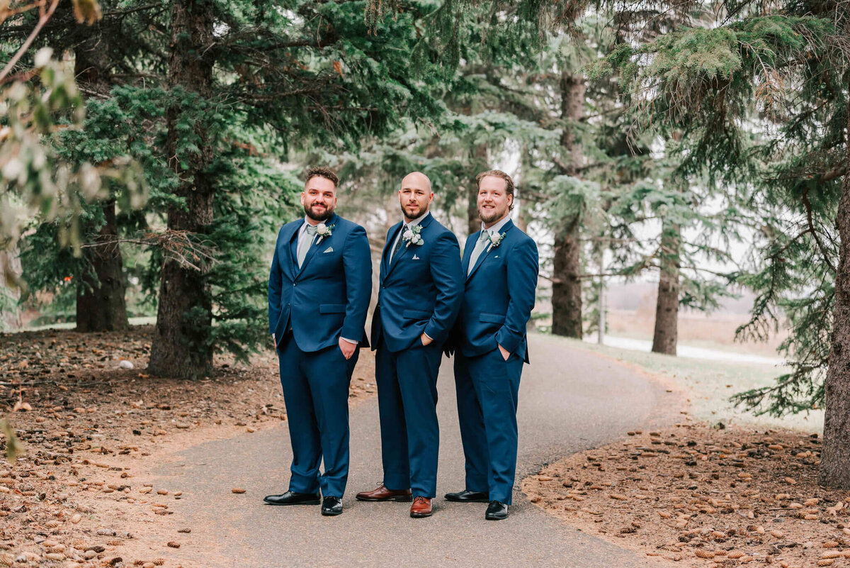 Groom and the groomsmen stand close together. 