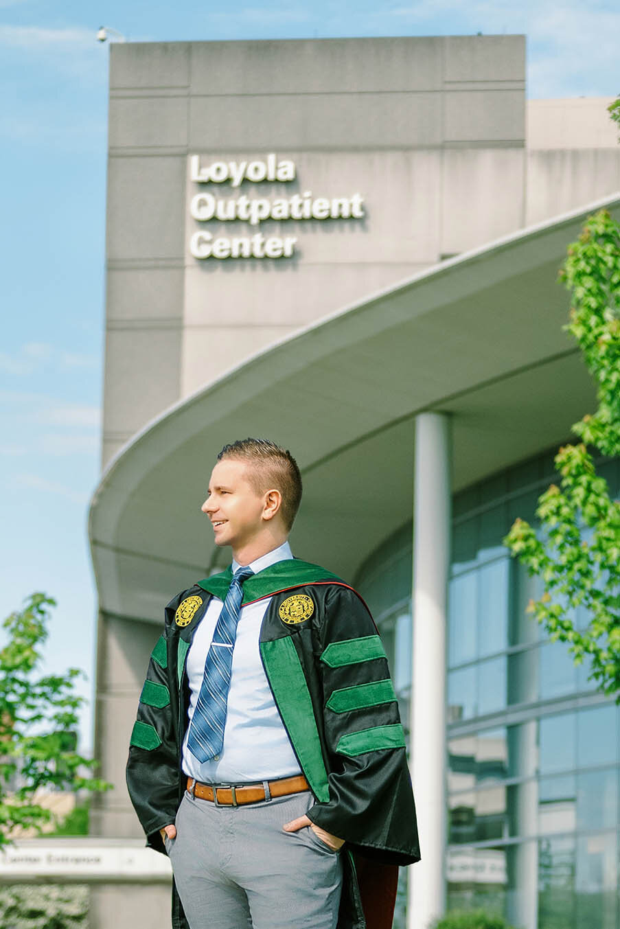 Medical school graduate standing in front of Loyola University Chicago's outpatient center