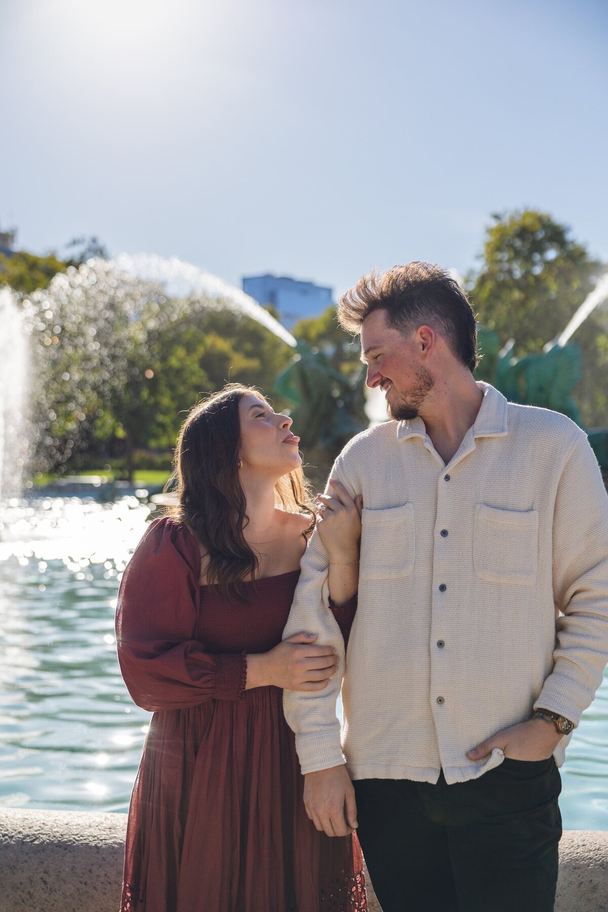 Joyful couple celebrating their engagement at the fountain.