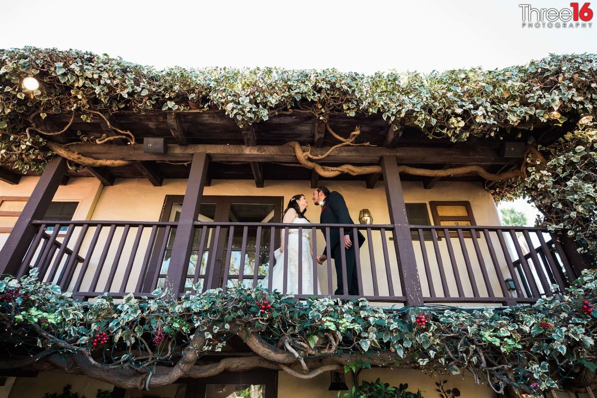Bride and Groom talk each other on the balcony at The Hacienda restaurant and wedding venue in Santa Ana