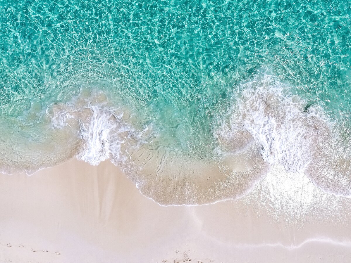 top-view-of-turquoise-ocean-waves-and-white-sandy-beach_t20_ZxEAYY