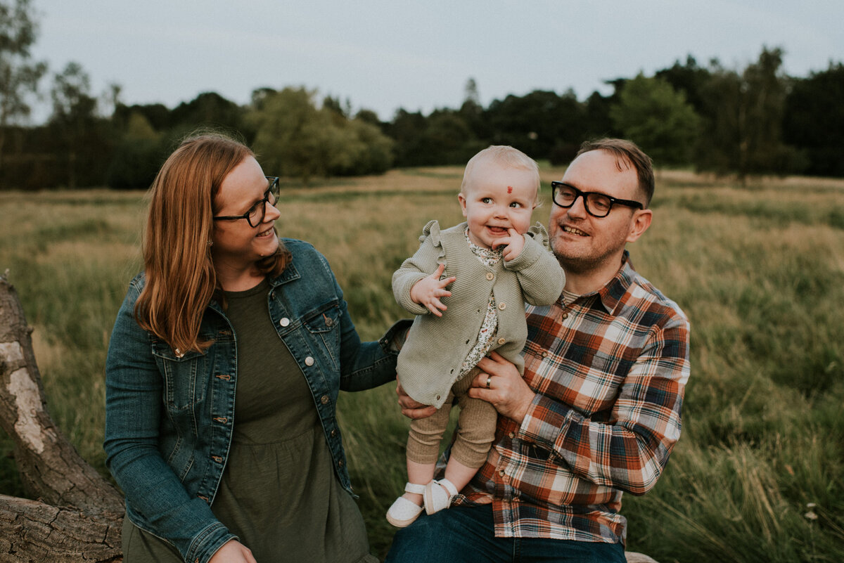 Couple holding toddler in outdoor countryside