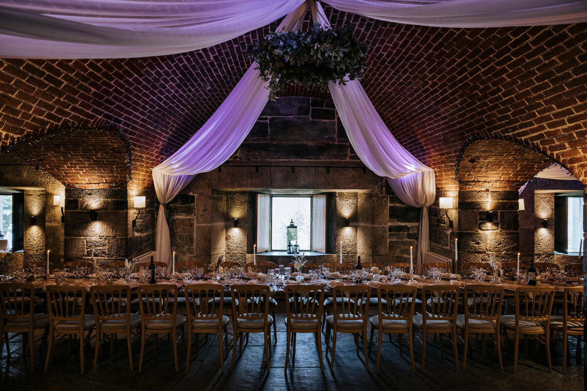 A banquet hall with tables, chairs and draping