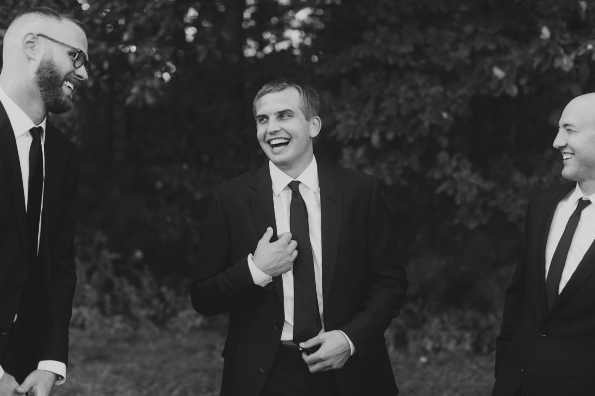 groom laughing with groomsmen during bridal party portraits