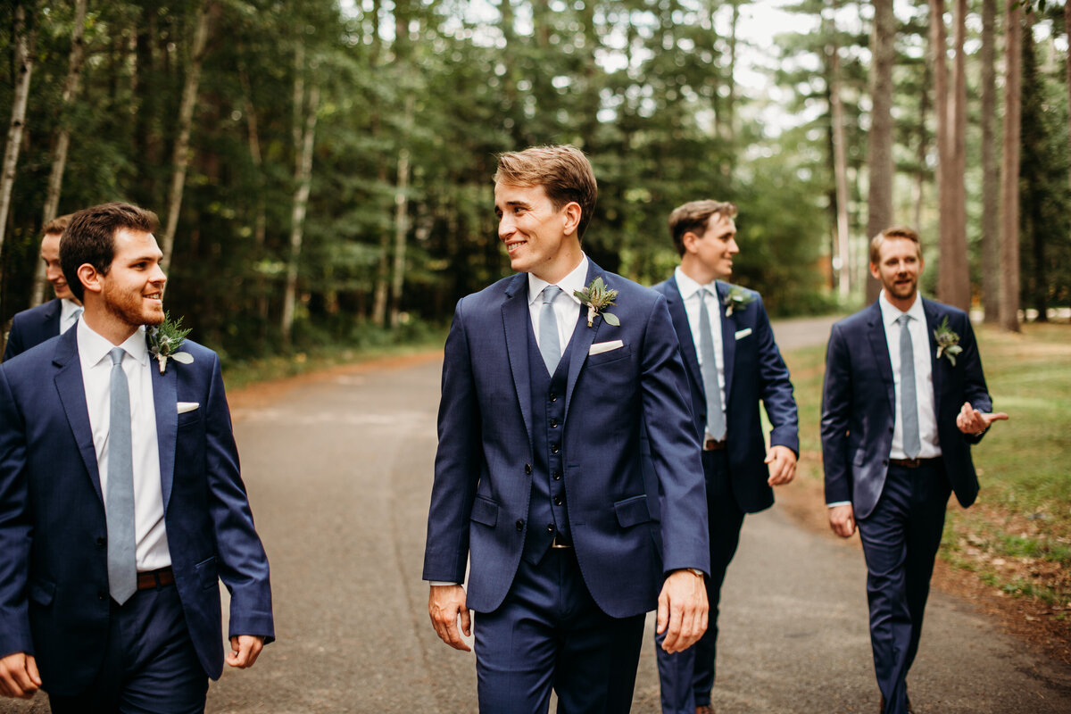 Groom and groomsmen walking and smiling at each other