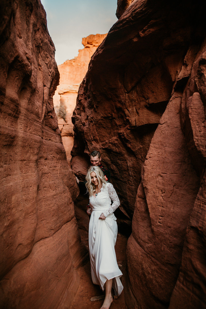 husband and wife walking through a canyon