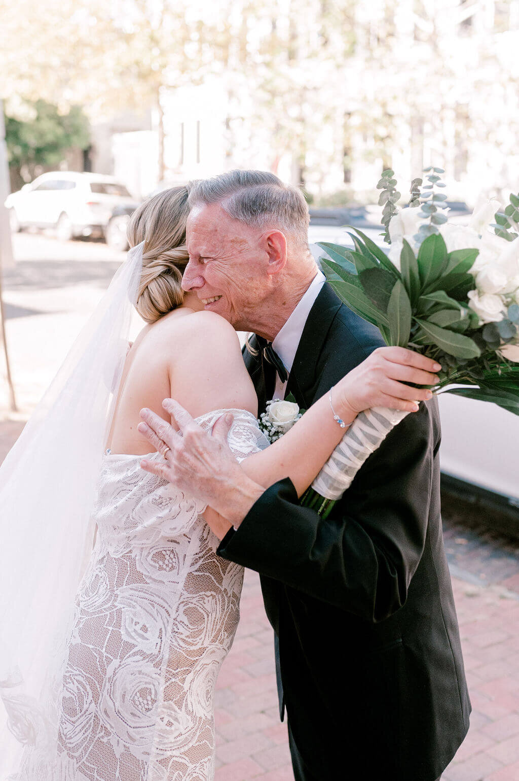 Intimate photograph of the father of the bride hugging  his daughter after he sees her for the first time.