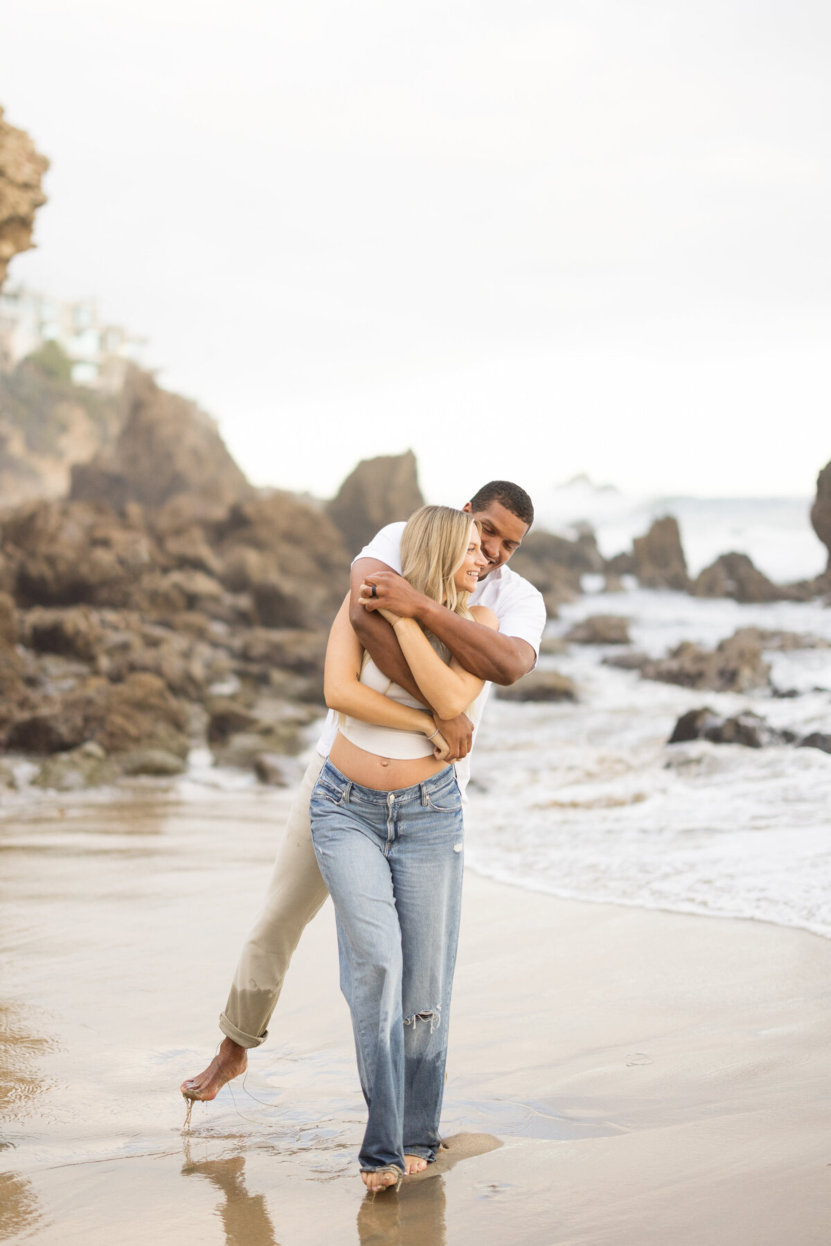 candid laughing maternity photo on the beach
