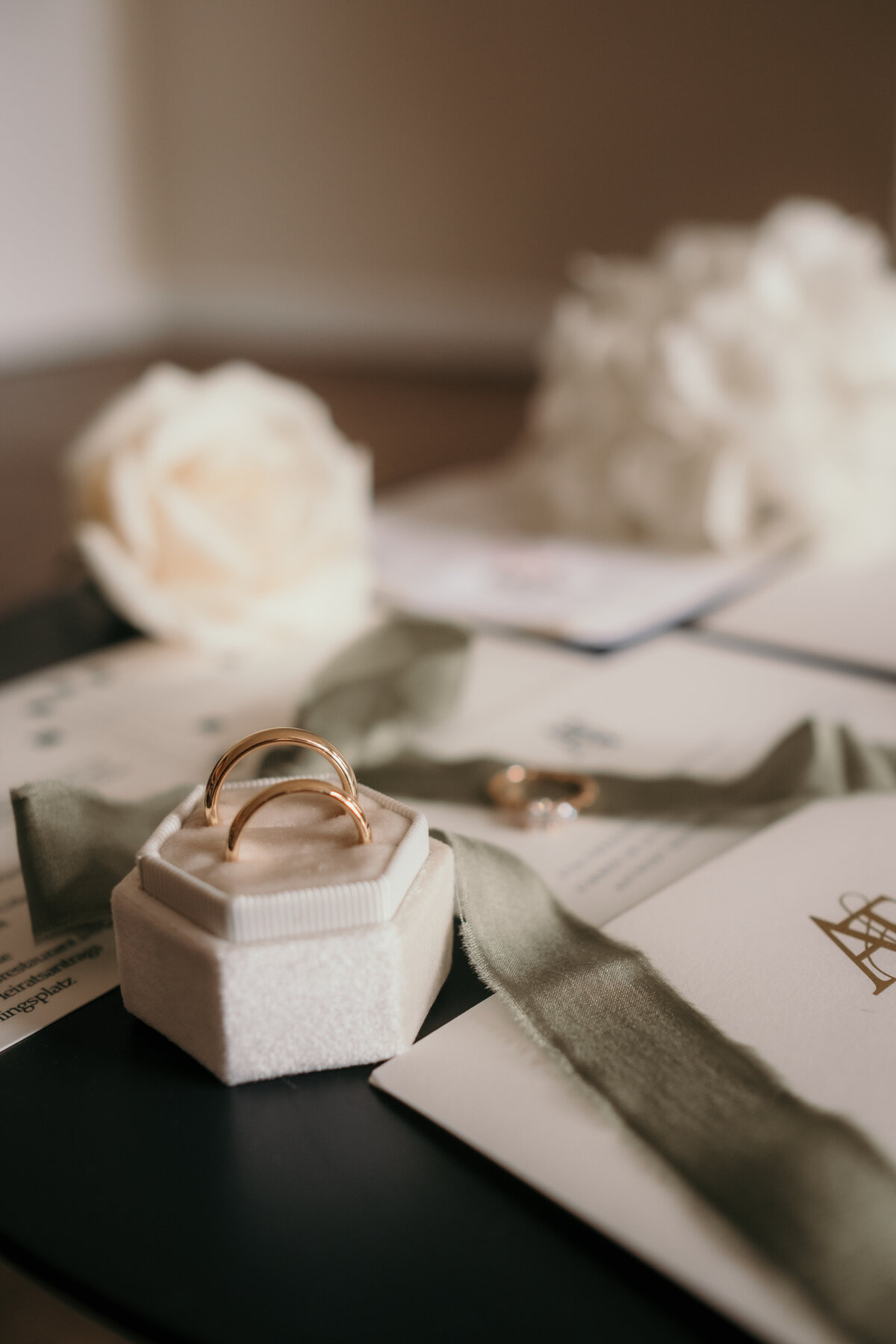 Detailshot of the wedding rings draped betweem some stationery.