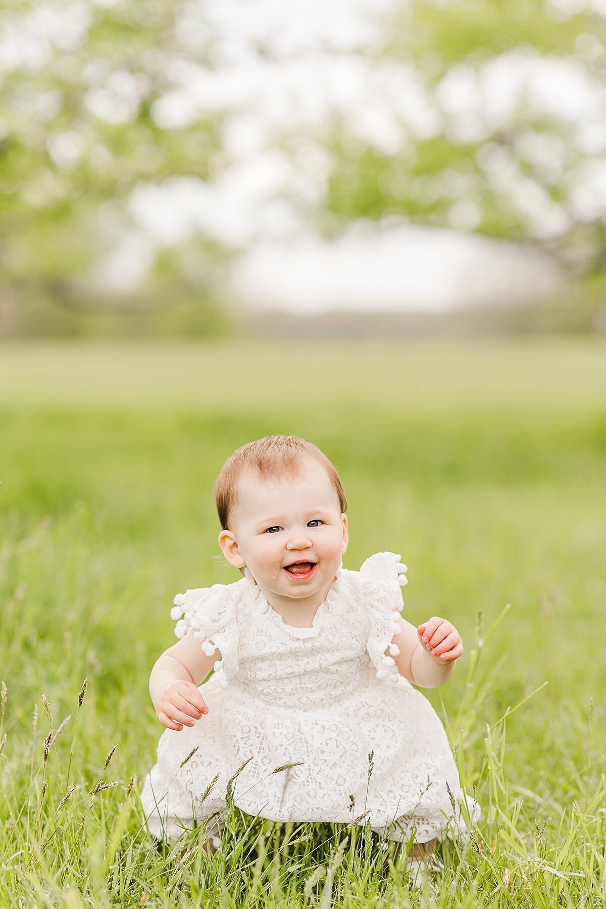 girl sits in grass  during Family photo session with Sara Sniderman Photography in Natick Massachusetts