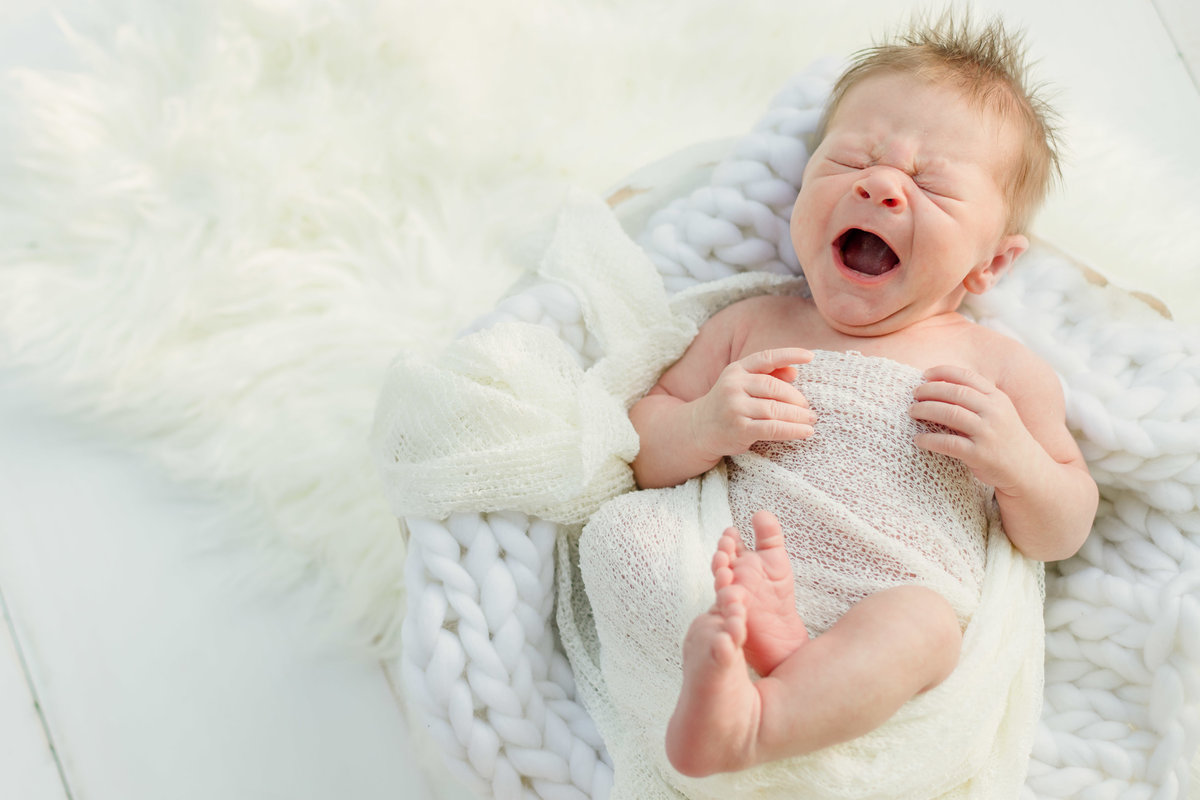 Mason yawning newborn in white