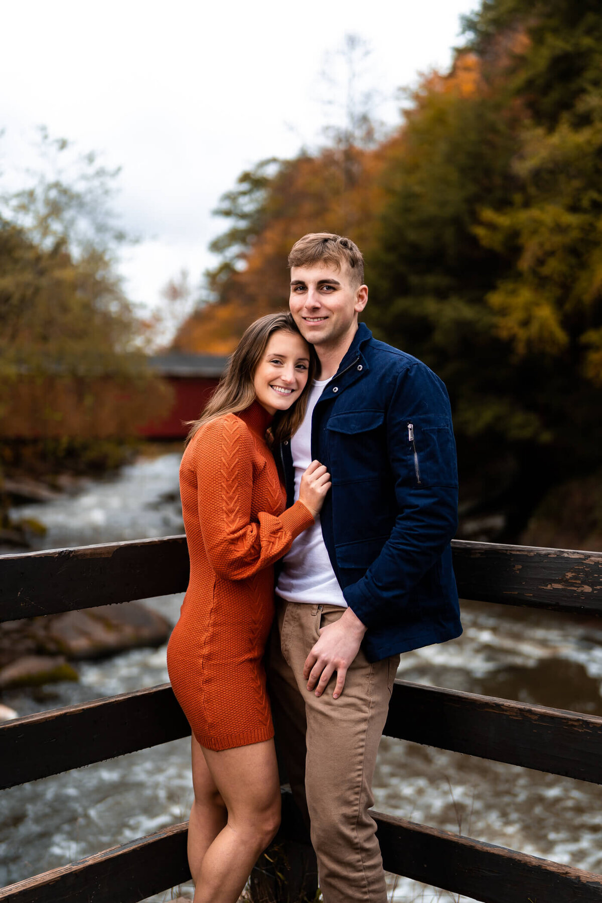 Pittsburgh engagement photos of a couple holding each other in front of the Mill at McConnell's Mill State Park, PA. Captured during golden hour sunset.