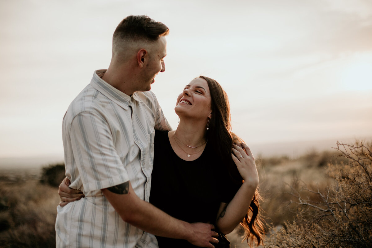 engaged couple holding and looking at each other