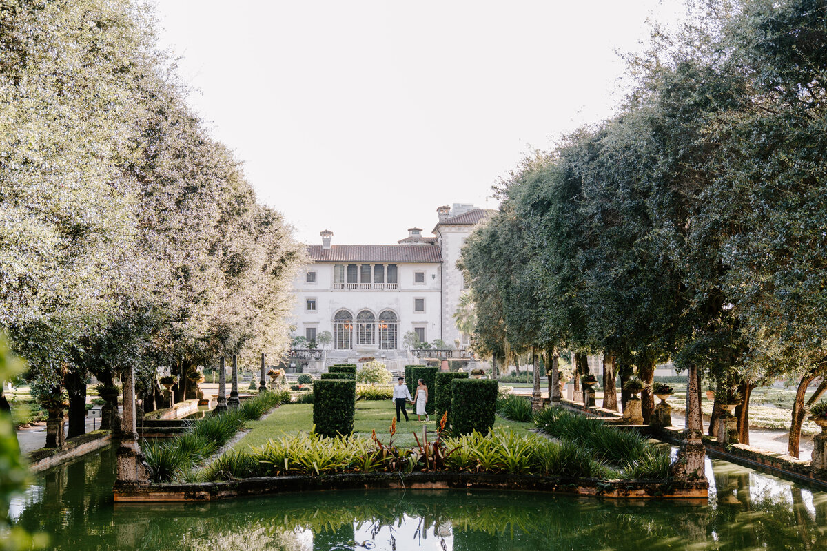 couple walking down outdoor stairs before archways