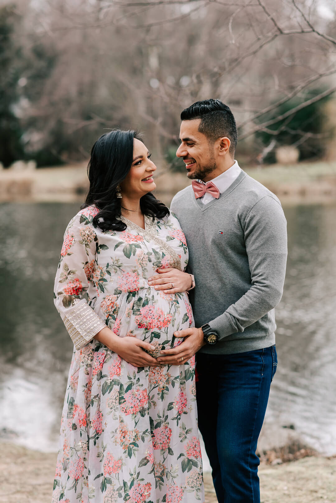 An indian couple happily looking at each other, expecting their first little one