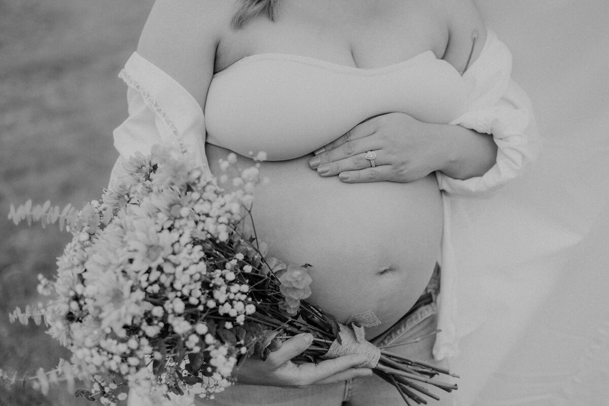 Close up of a pregnant belly with flowers