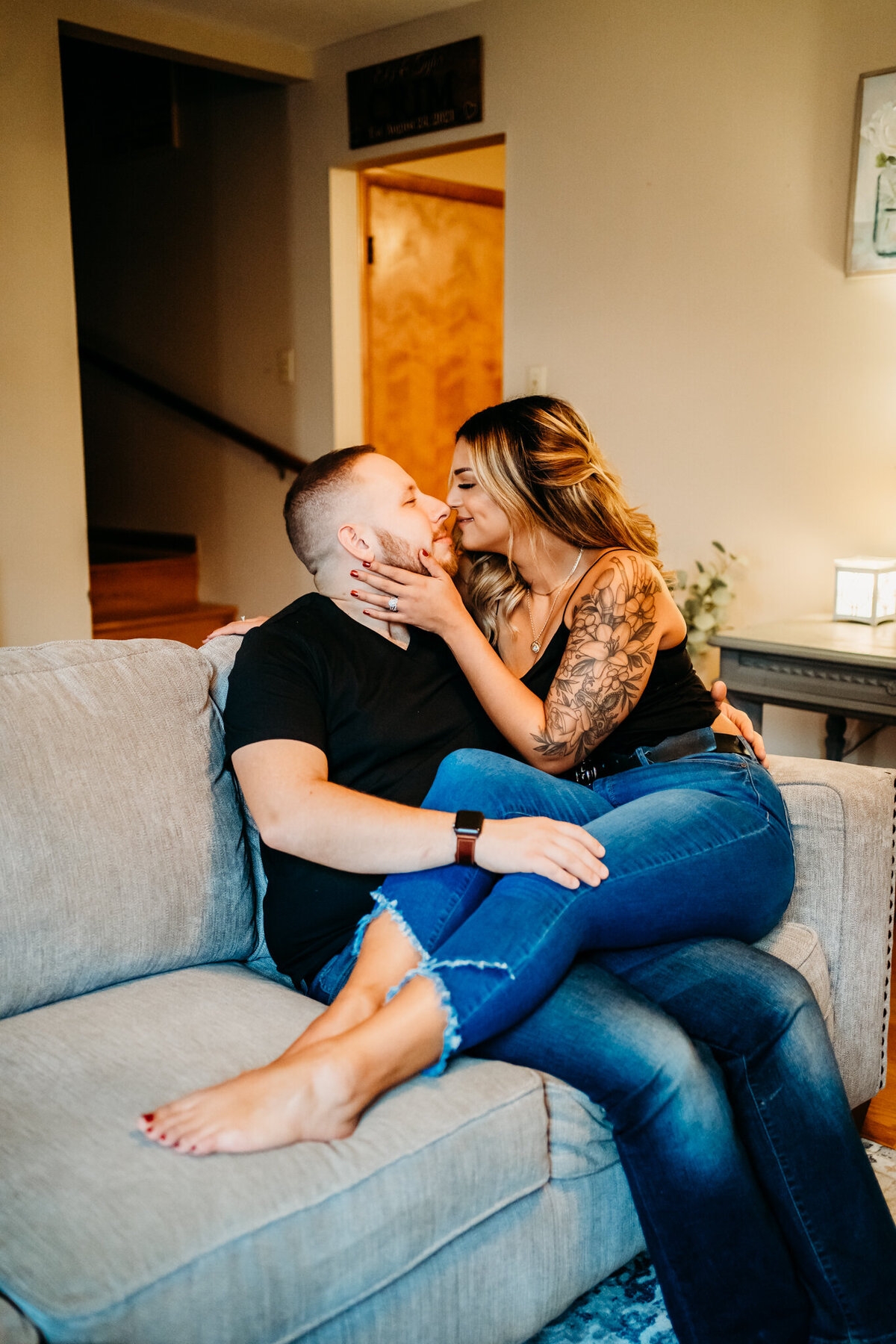 Couple cuddling on a couch during an at-home sessi