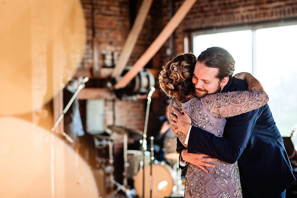 Groom hugging his mother at the end of their dance together
