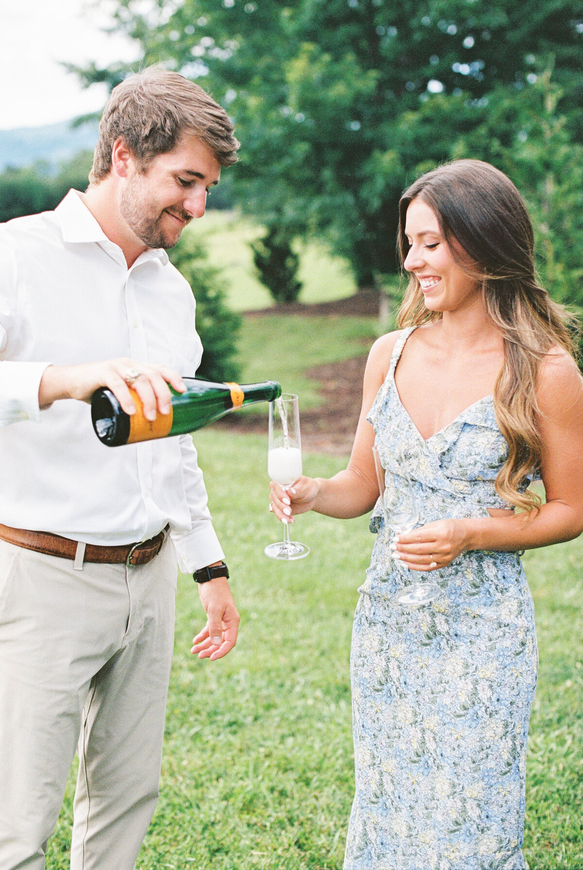 couple sharing champagne toast during  hotel domestique engagement session