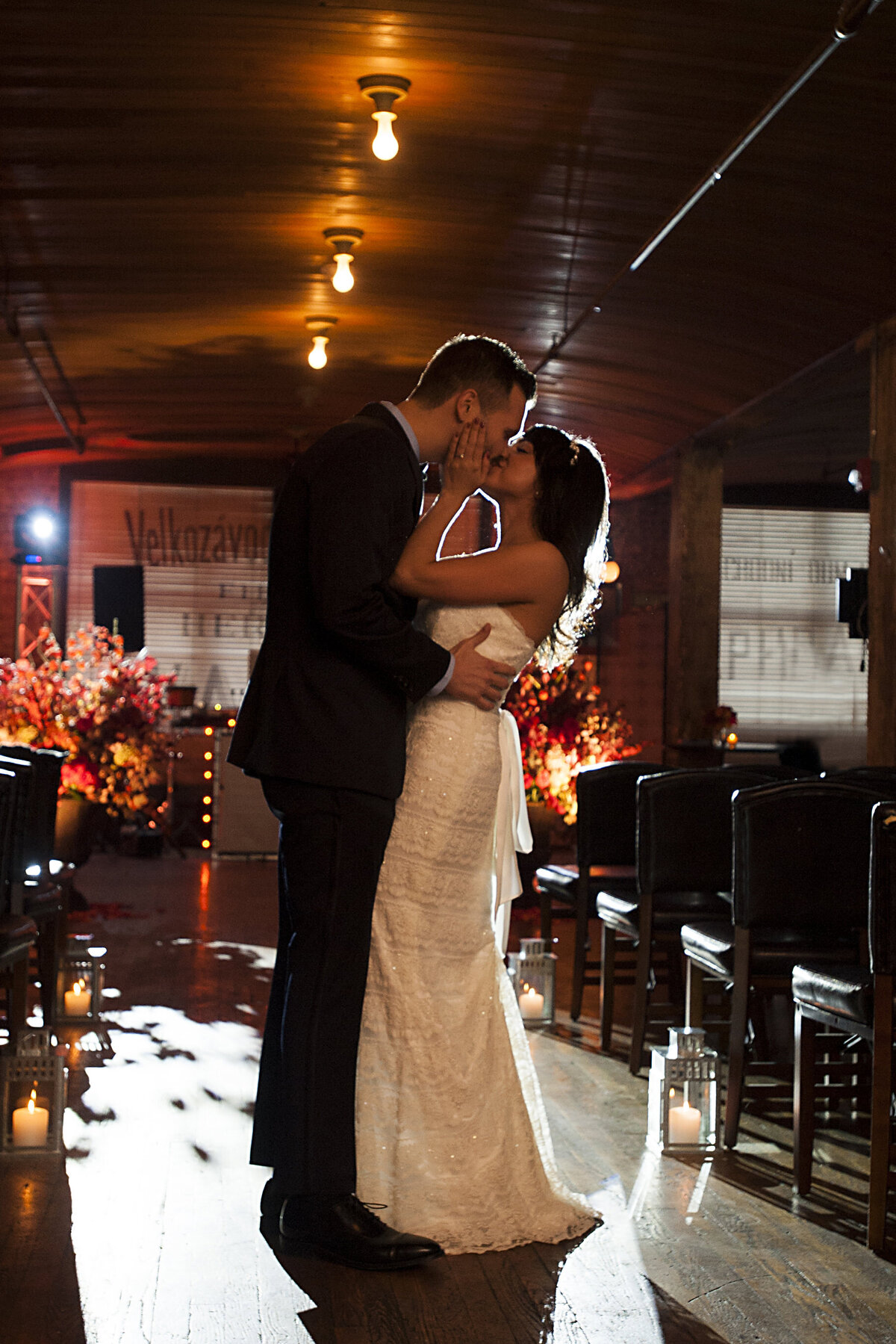 A wedding couple kissing in a dark room 